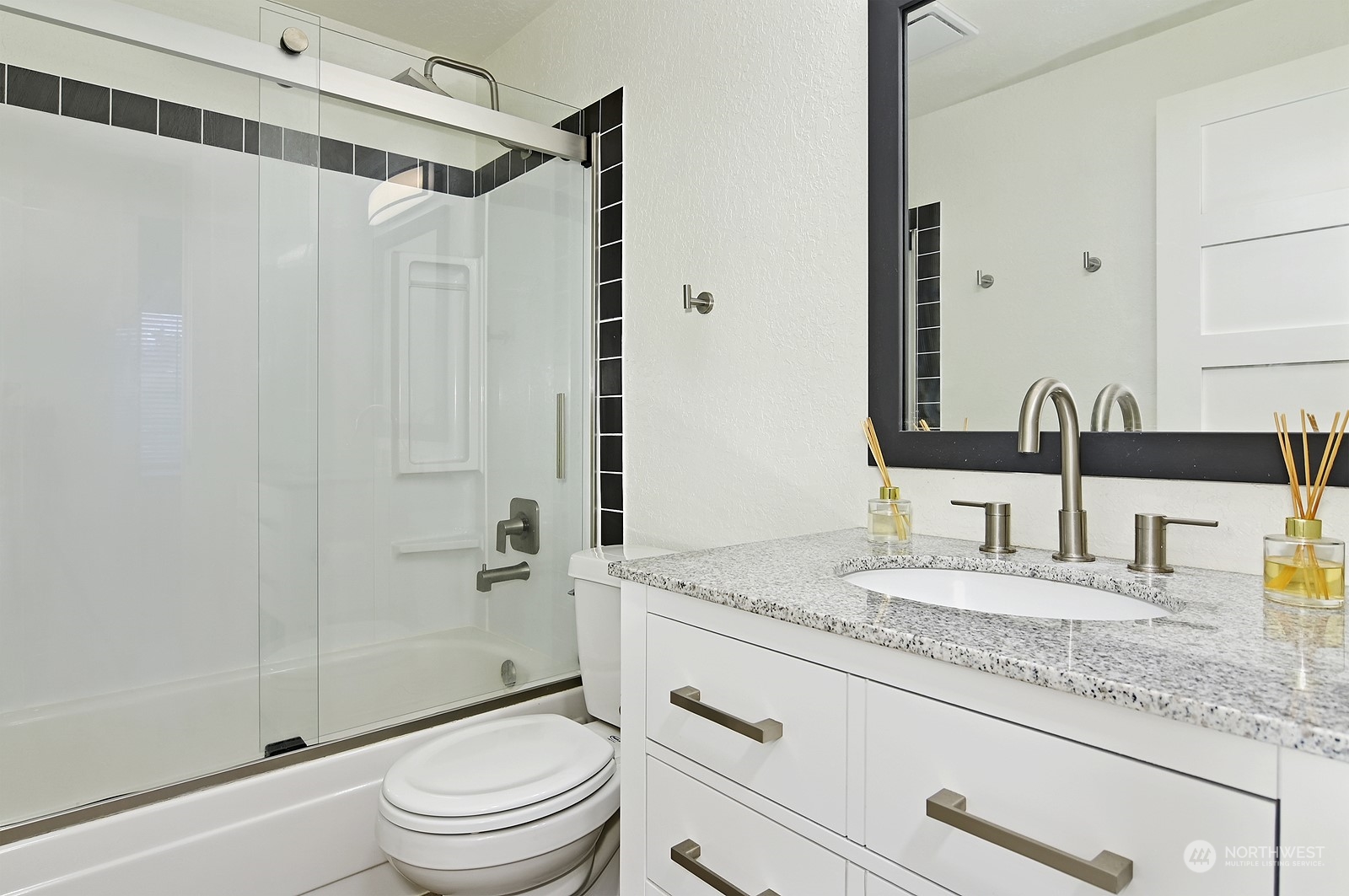 14401 Southeast Petrovitsky Road, Unit D105 Renton, WA 98058 - Photo 17 of 25 a bathroom with a granite countertop sink toilet mirror and shower