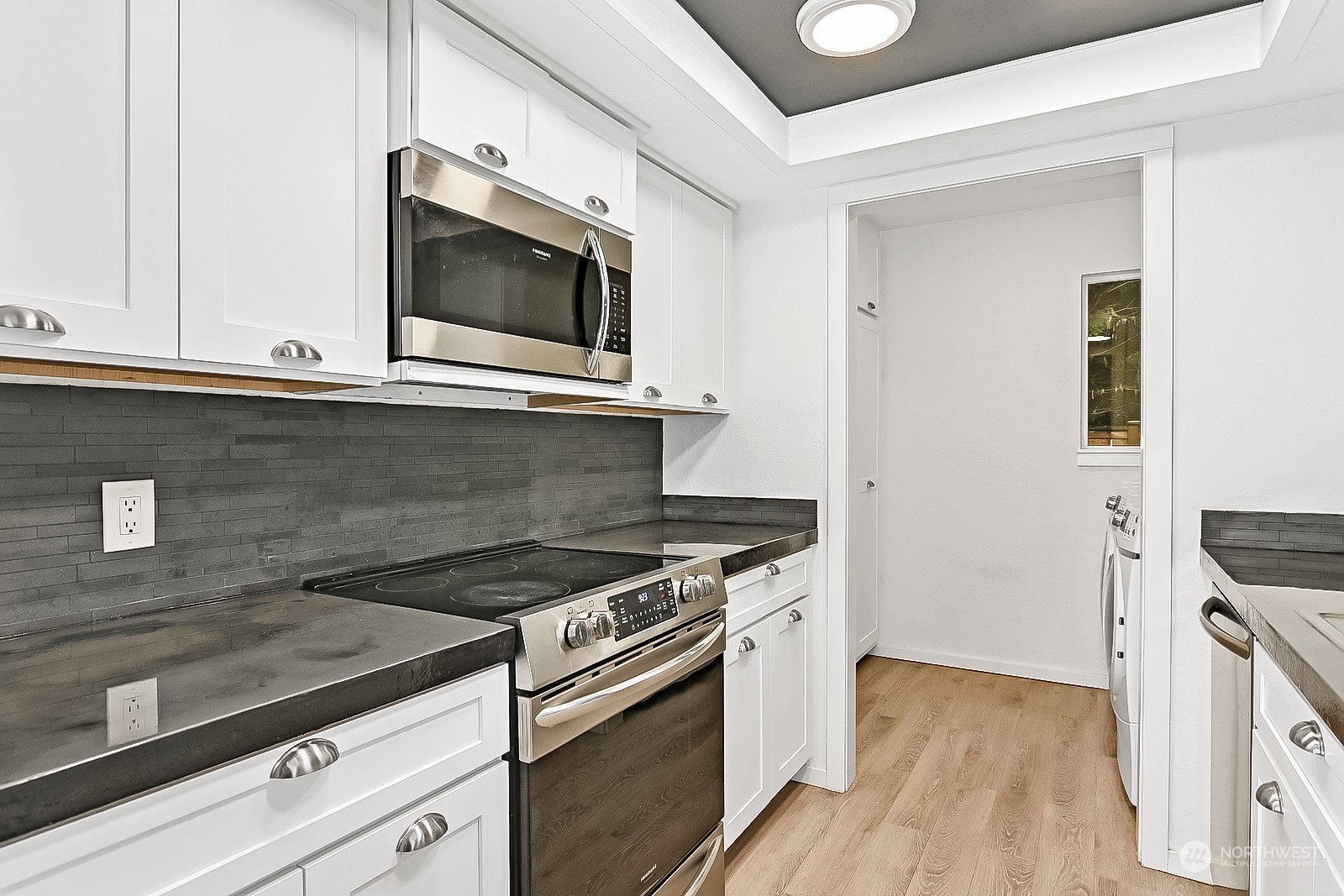 14401 Southeast Petrovitsky Road, Unit D105 Renton, WA 98058 - Photo 6 of 25 a kitchen with granite countertop a stove and a microwave