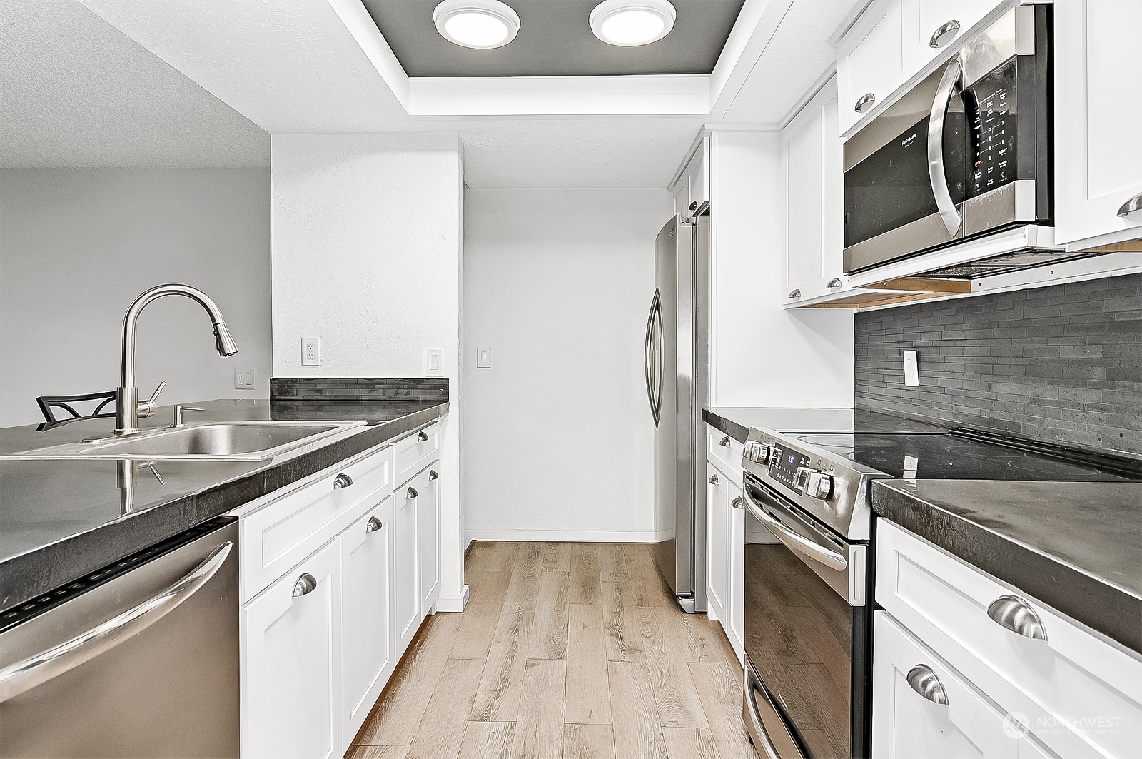 14401 Southeast Petrovitsky Road, Unit D105 Renton, WA 98058 - Photo 7 of 25 a kitchen with stainless steel appliances granite countertop a stove and a sink