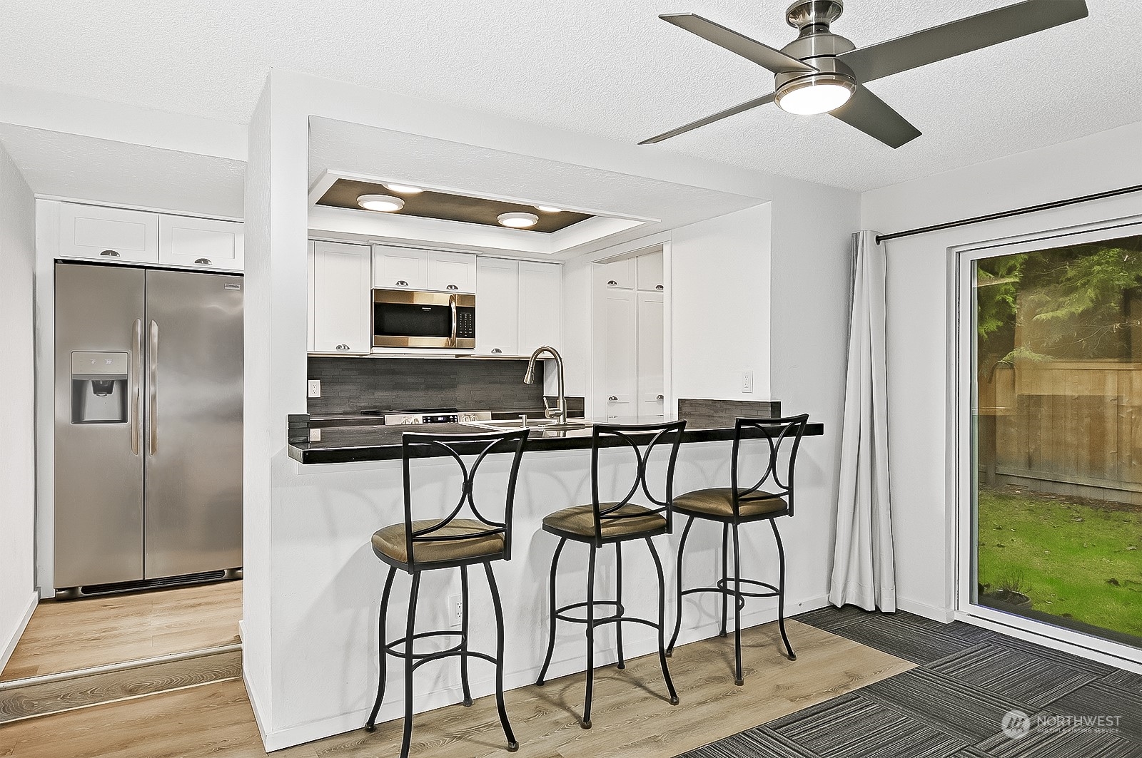 14401 Southeast Petrovitsky Road, Unit D105 Renton, WA 98058 - Photo 10 of 25 a kitchen with stainless steel appliances a stove a refrigerator and a microwave