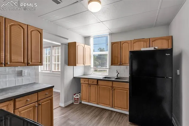 a kitchen with a sink a refrigerator and cabinets