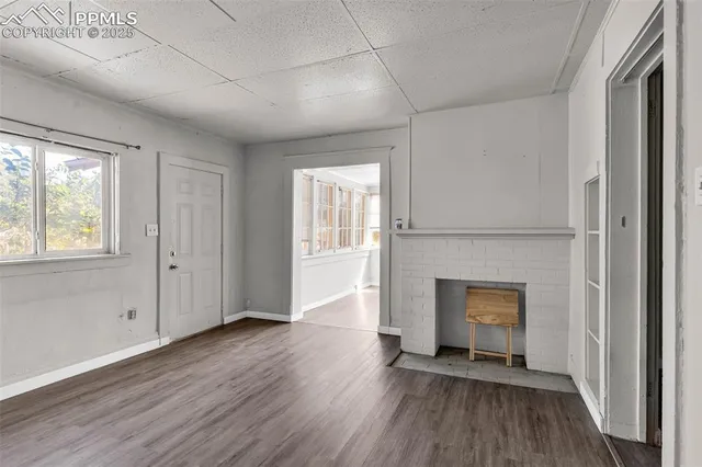 a view of an empty room with a fireplace and a window
