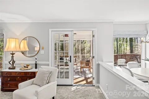 a living room with furniture a mirror and a large window