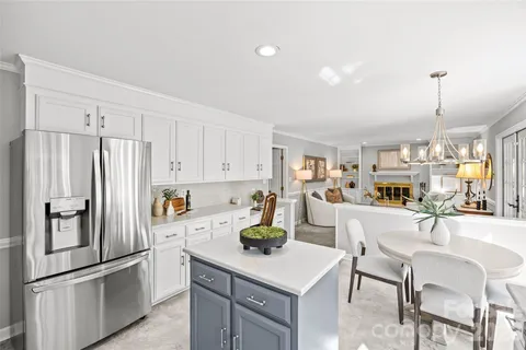 a kitchen with a refrigerator a stove a dining table and chairs