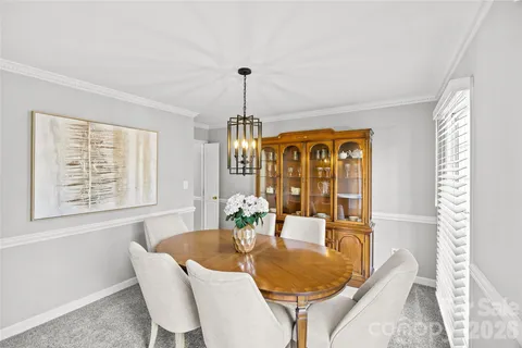 a dining room with furniture a chandelier and wooden floor