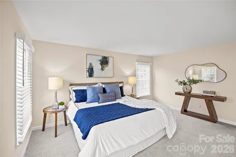 a bedroom with a bed mirror and a large window