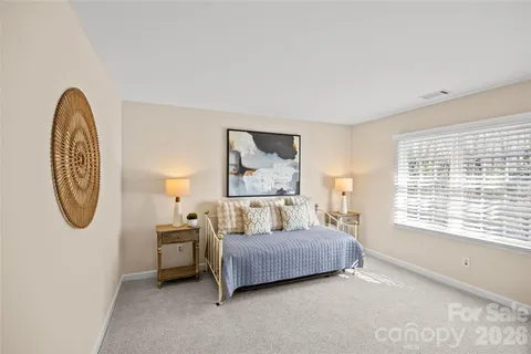 a bedroom with a bed a mirror and a window