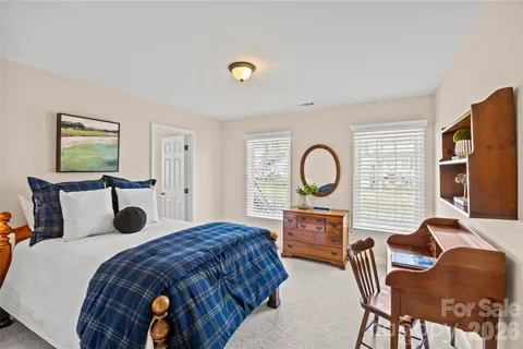 a bedroom with a bed a table and chair