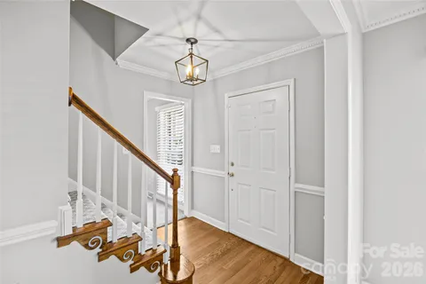 a view of a hallway with wooden floor and staircase