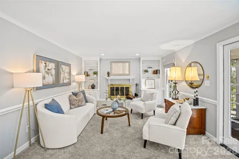a living room with fireplace furniture and a large window
