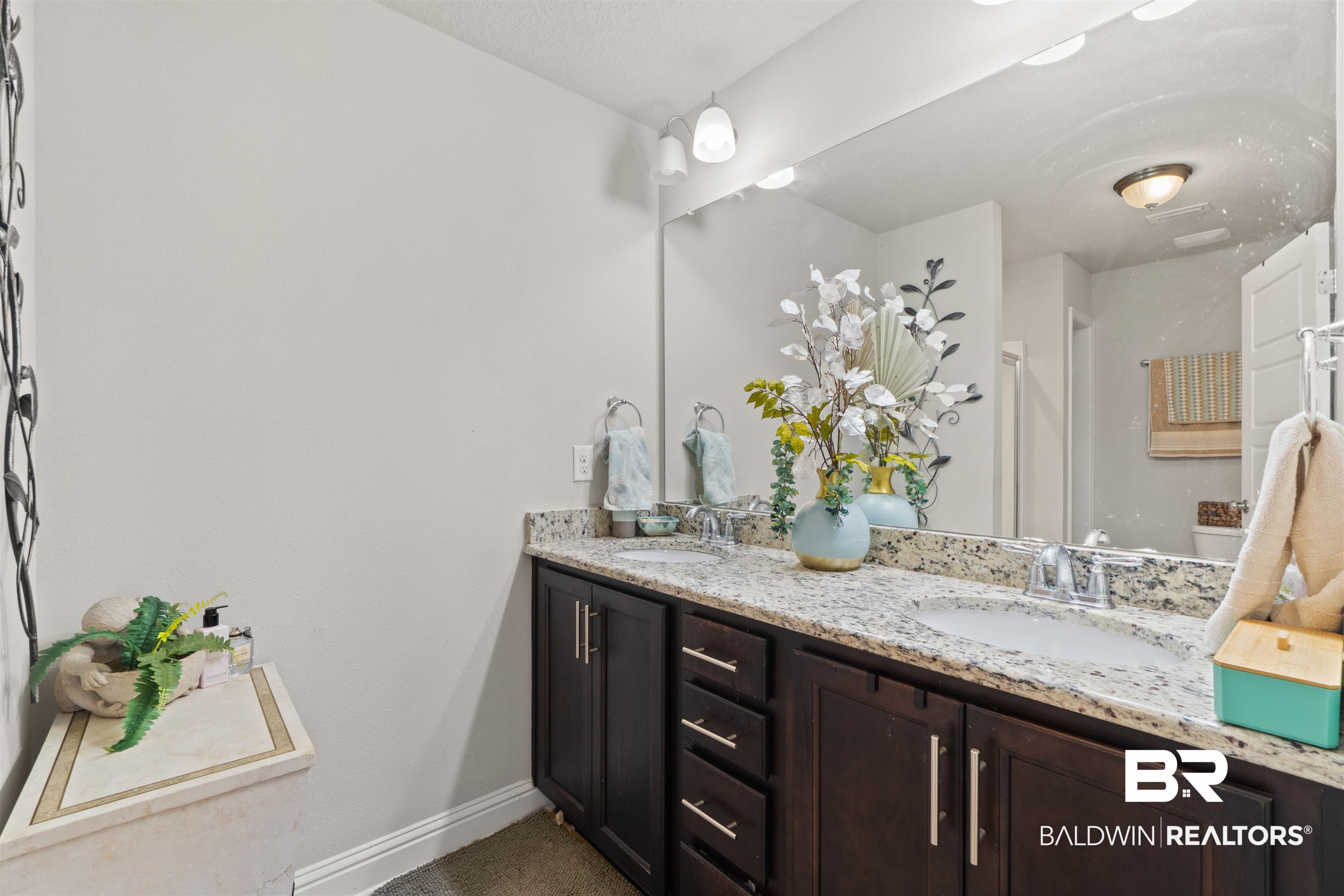 25806 Pollard Road, Unit 6 Daphne, AL 36526 - Photo 25 of 38 Dual vanity with granite countertop, integrated sinks, dark wood-finish cabinetry, and a large wall-mounted mirror
