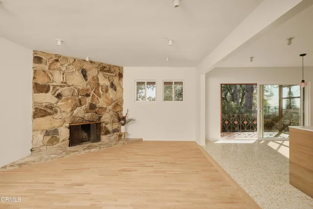 a view of an empty room with a fireplace and a window