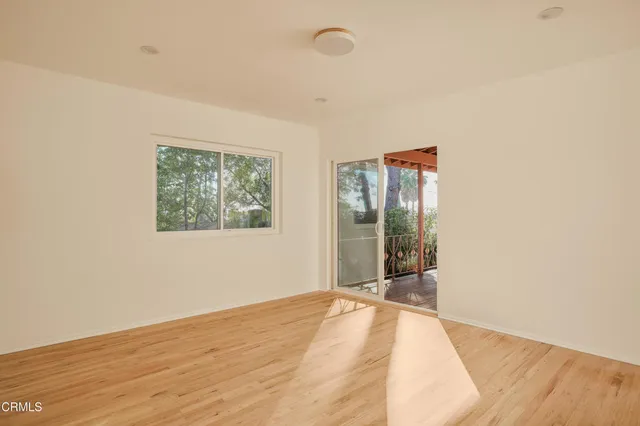 an empty room with wooden floor and window