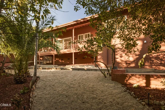 a view of a house with backyard and trees