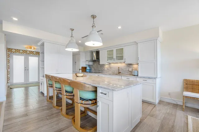 a large kitchen with stainless steel appliances granite countertop lots of counter space and a sink