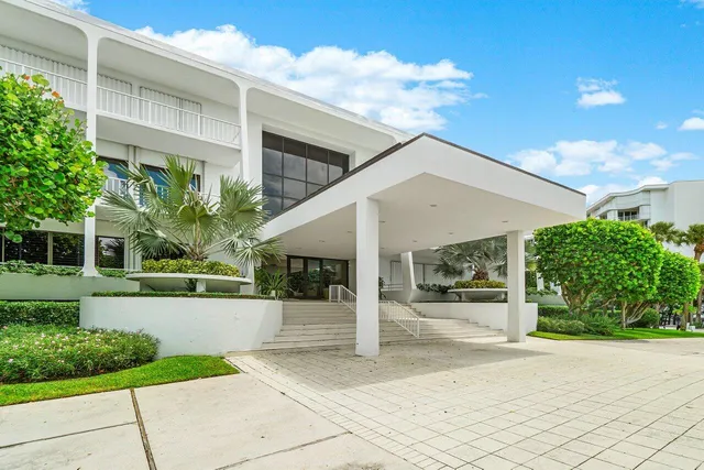 a view of a white house with a yard and plants