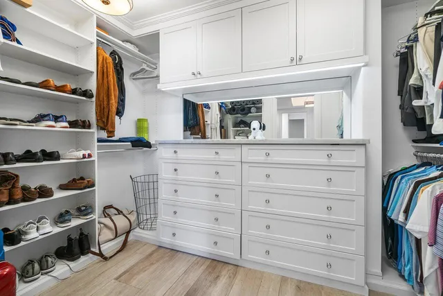 a bedroom with a bed and a flat tv screen on dresser