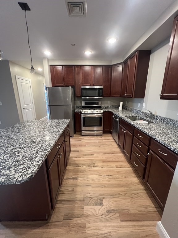 40 Ames Avenue, Unit 302 Canton, MA 02021 - Photo 1 of 1 a large kitchen with stainless steel appliances kitchen island granite countertop a large counter top a stove a sink and a refrigerator