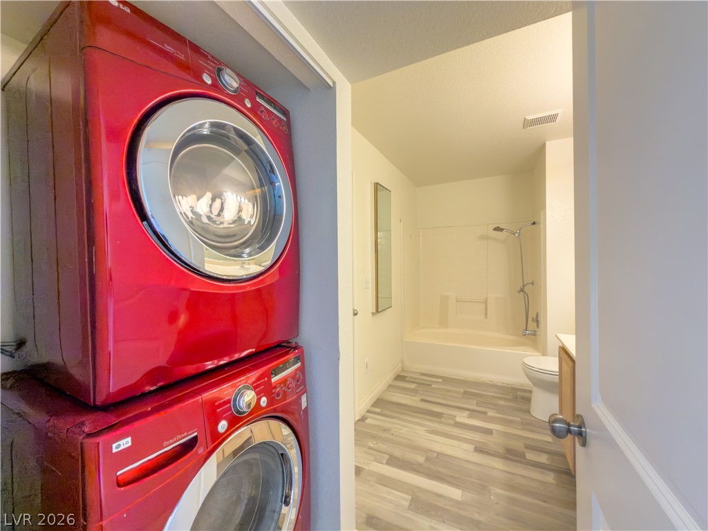 8070 West Russell Road, Unit 2063 Las Vegas, NV 89113 - Photo 5 of 9 Tidy laundry area adjoins a clean bathroom with wood plank flooring and shower-tub combination.