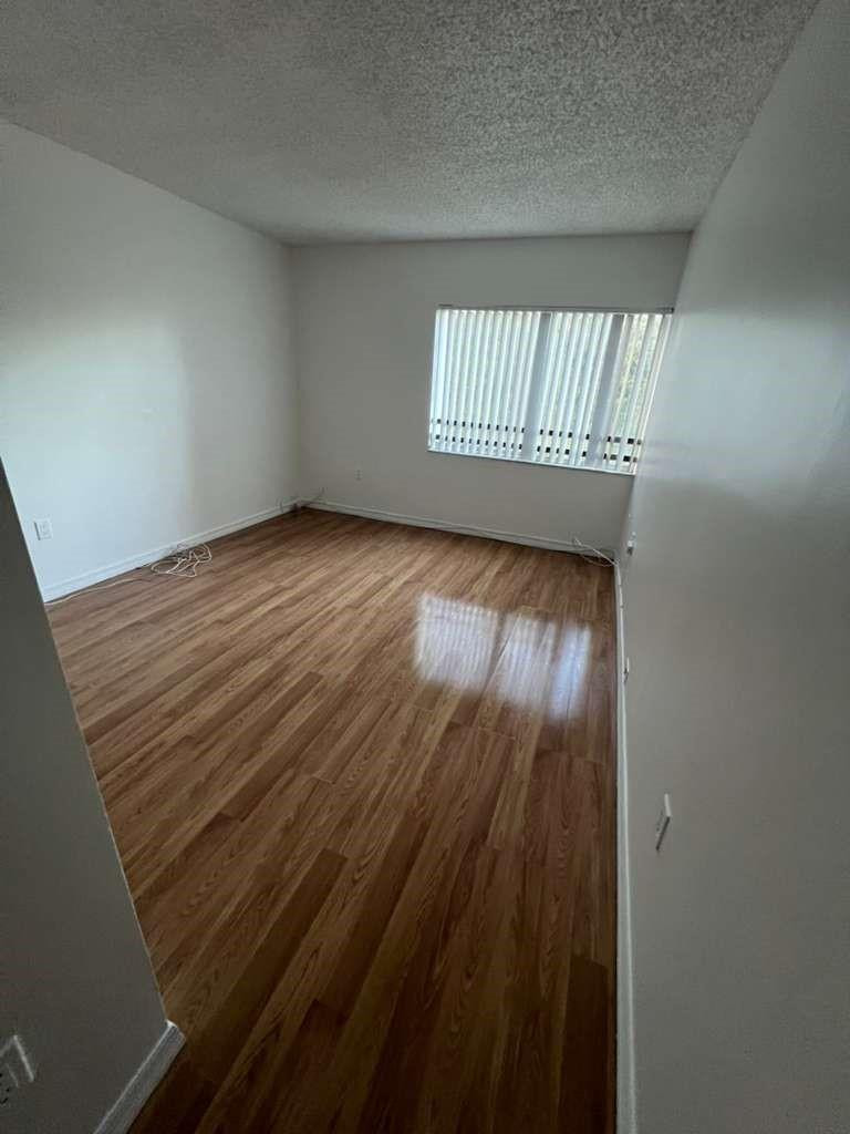 Undisclosed Address Plantation, FL 33324 - Photo 15 of 16 a view of an empty room with wooden floor and a window