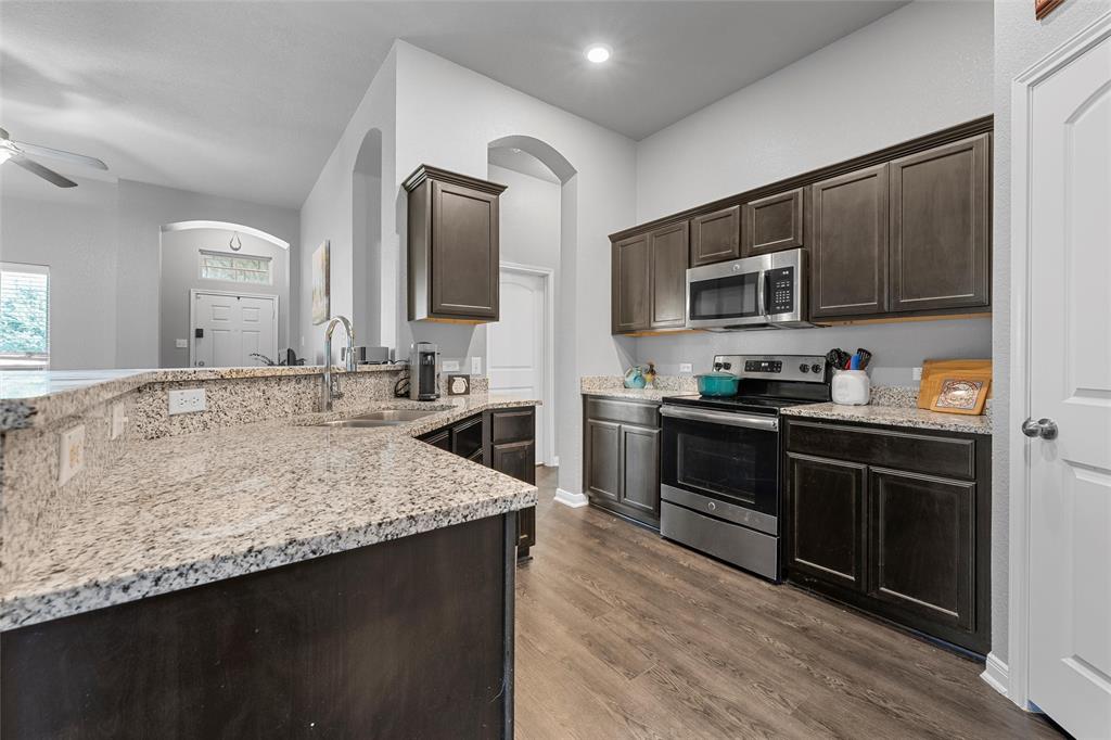 1214 Merganser Way Waco, TX 76706 - Photo 6 of 14 a kitchen with stainless steel appliances granite countertop a stove a sink and a microwave