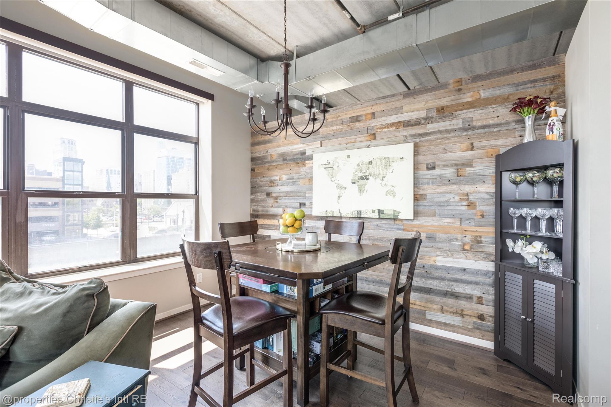 66 Winder Street, Unit 332 Detroit, MI 48201 - Photo 12 of 30 Dining space featuring wood walls, wood finished floors, an accent wall, and suspended lighting