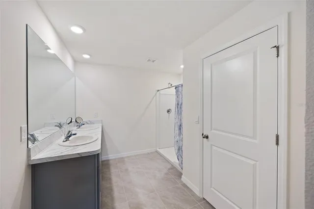 a bathroom with double vanity sink and a mirror