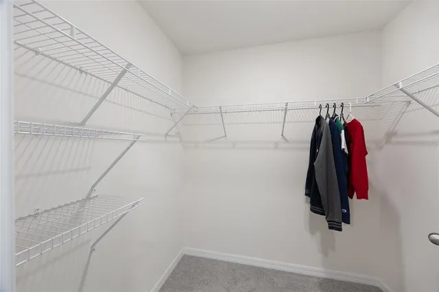 a view of walk in closet with clothes