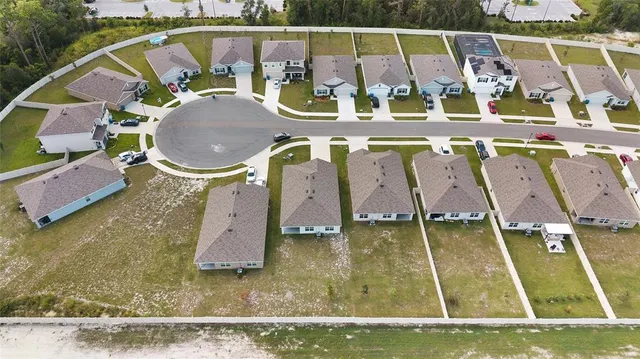 an aerial view of a swimming pool with outdoor seating