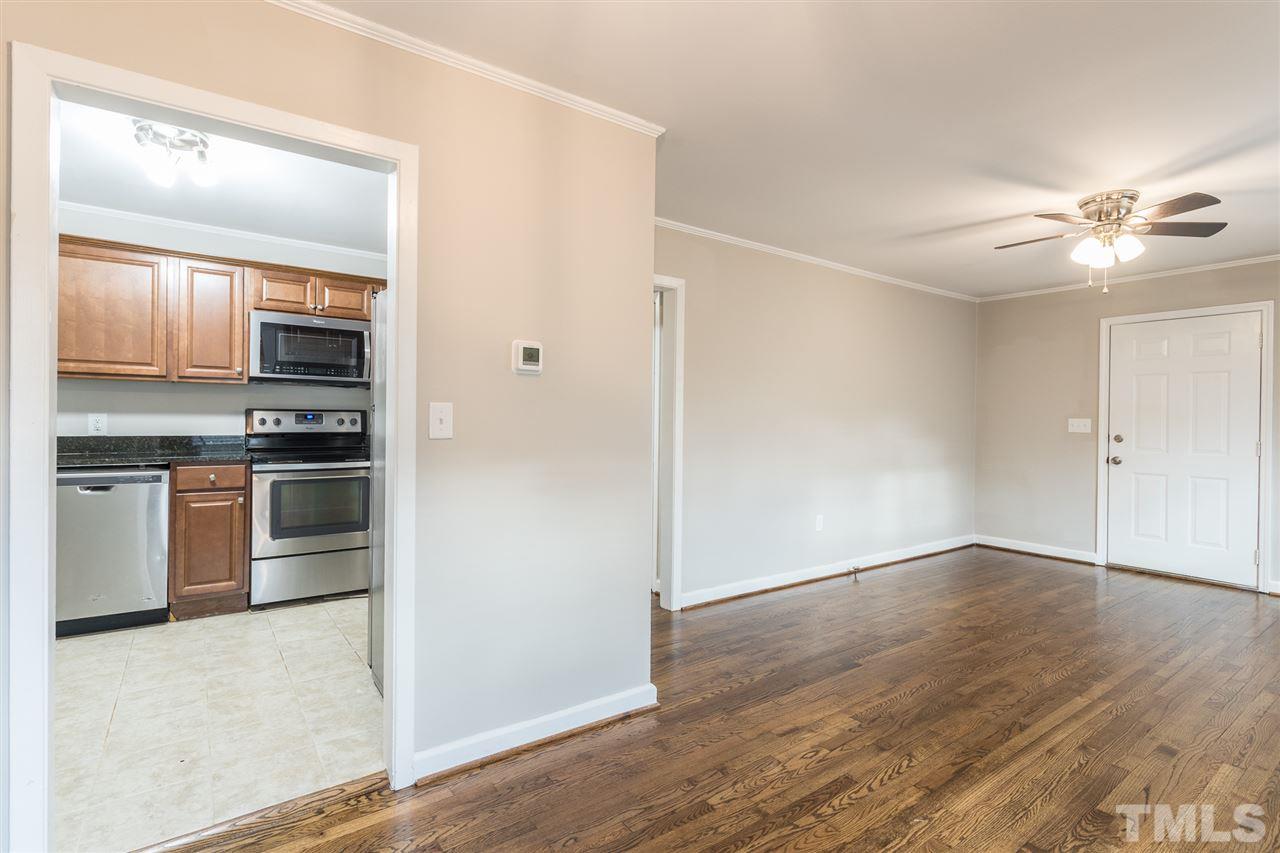 2732 Knowles Street Raleigh, NC 27603 - Photo 5 of 26 an empty room with wooden floor kitchen view and a window