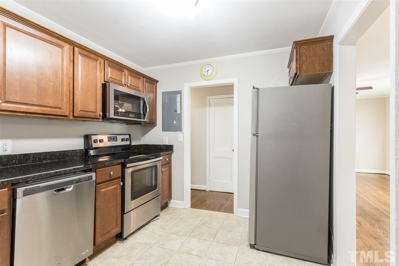 2732 Knowles Street Raleigh, NC 27603 - Photo 10 of 26 a kitchen with stainless steel appliances granite countertop white cabinets a stove top oven a sink and dishwasher