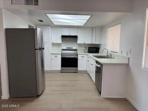 a kitchen with stainless steel appliances a stove a sink and a refrigerator