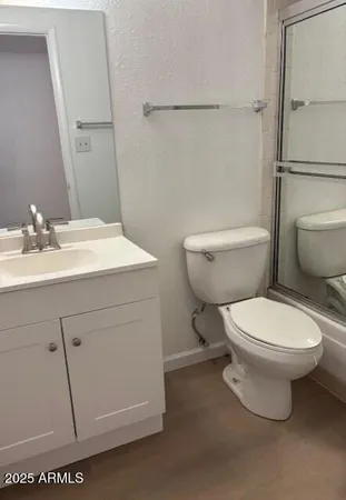 a bathroom with a toilet sink vanity and mirror