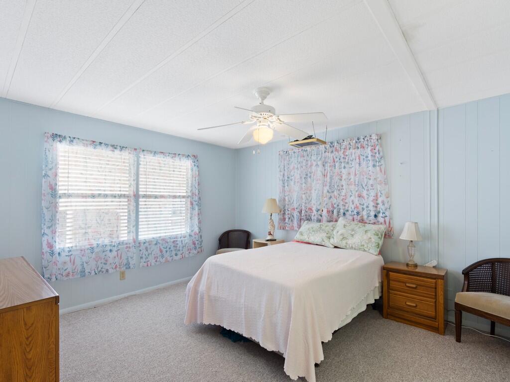 4800 Southeast Federal Highway, Unit 93 Stuart, FL 34997 - Photo 15 of 25 a bedroom with a bed and a chandelier