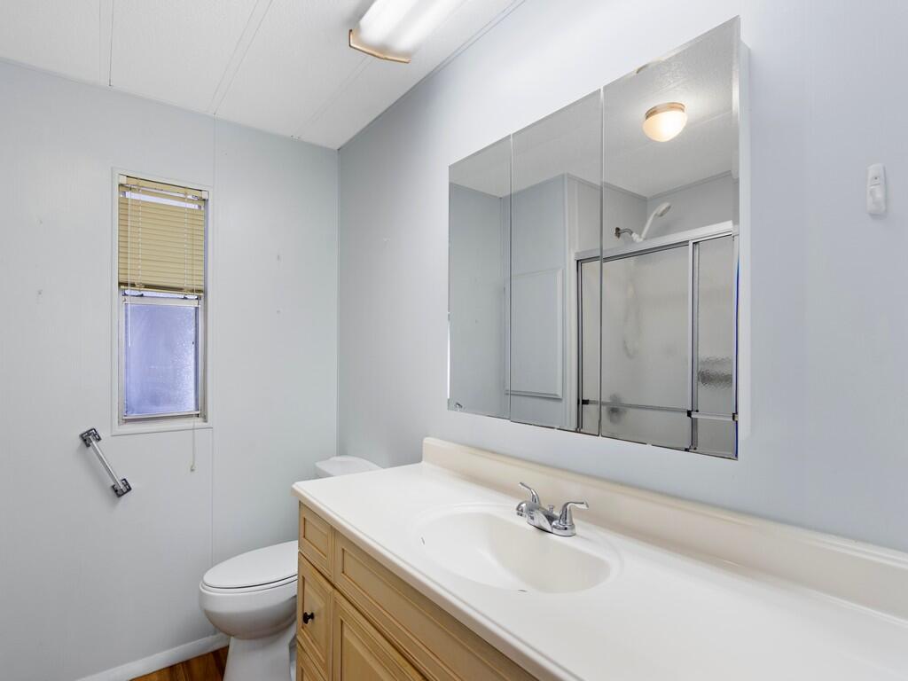 4800 Southeast Federal Highway, Unit 93 Stuart, FL 34997 - Photo 18 of 25 a bathroom with a sink toilet and vanity