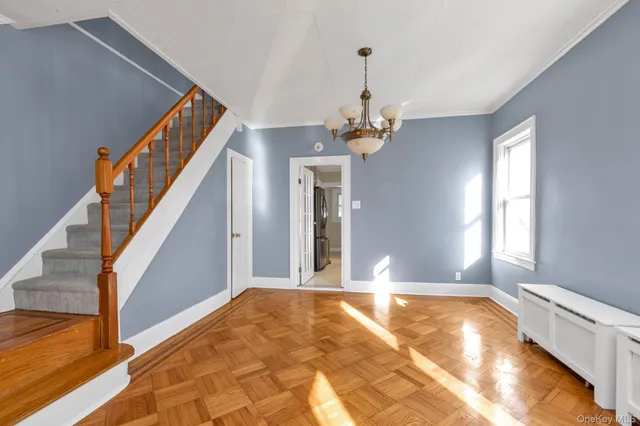 a view of a livingroom with wooden floor and staircase