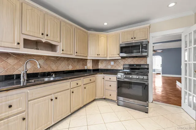 a kitchen with stainless steel appliances granite countertop a stove a sink and a microwave