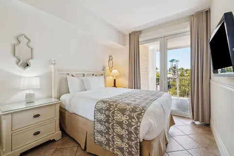 a bedroom with a bed and a flat tv screen on the dresser