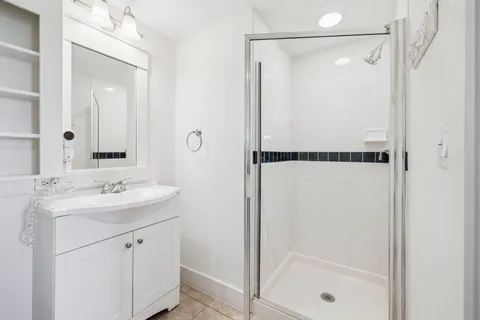 a bathroom with a shower sink and mirror