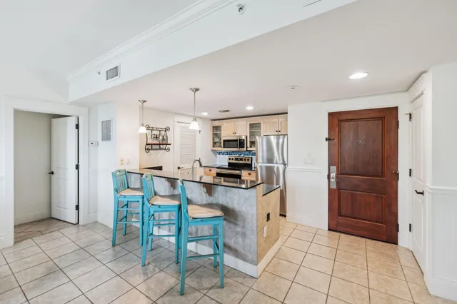 a kitchen with stainless steel appliances kitchen island granite countertop a refrigerator and cabinets