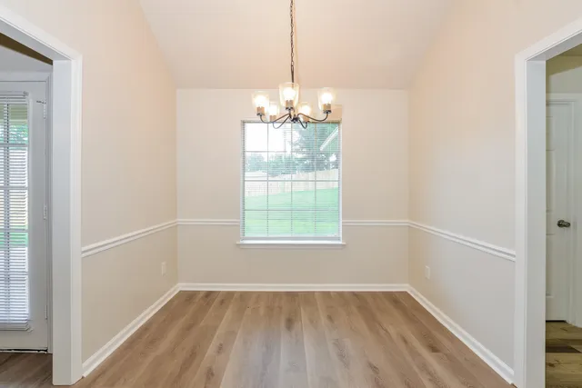 a view of a room with wooden floor and windows