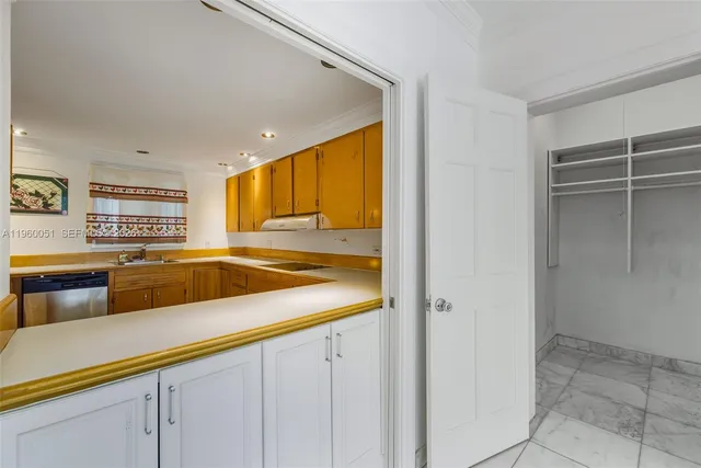 a view of an empty room with cabinet and mirrors