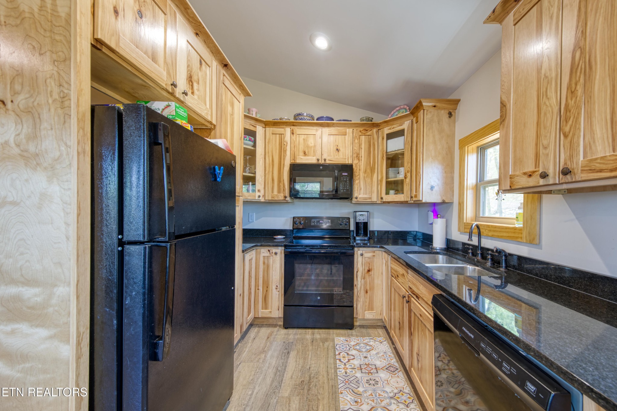 1040 Rdg Pt Trail Dandridge, TN 37725 - Photo 16 of 31 a kitchen with stainless steel appliances granite countertop a refrigerator a sink dishwasher a stove and a dining table with wooden floor