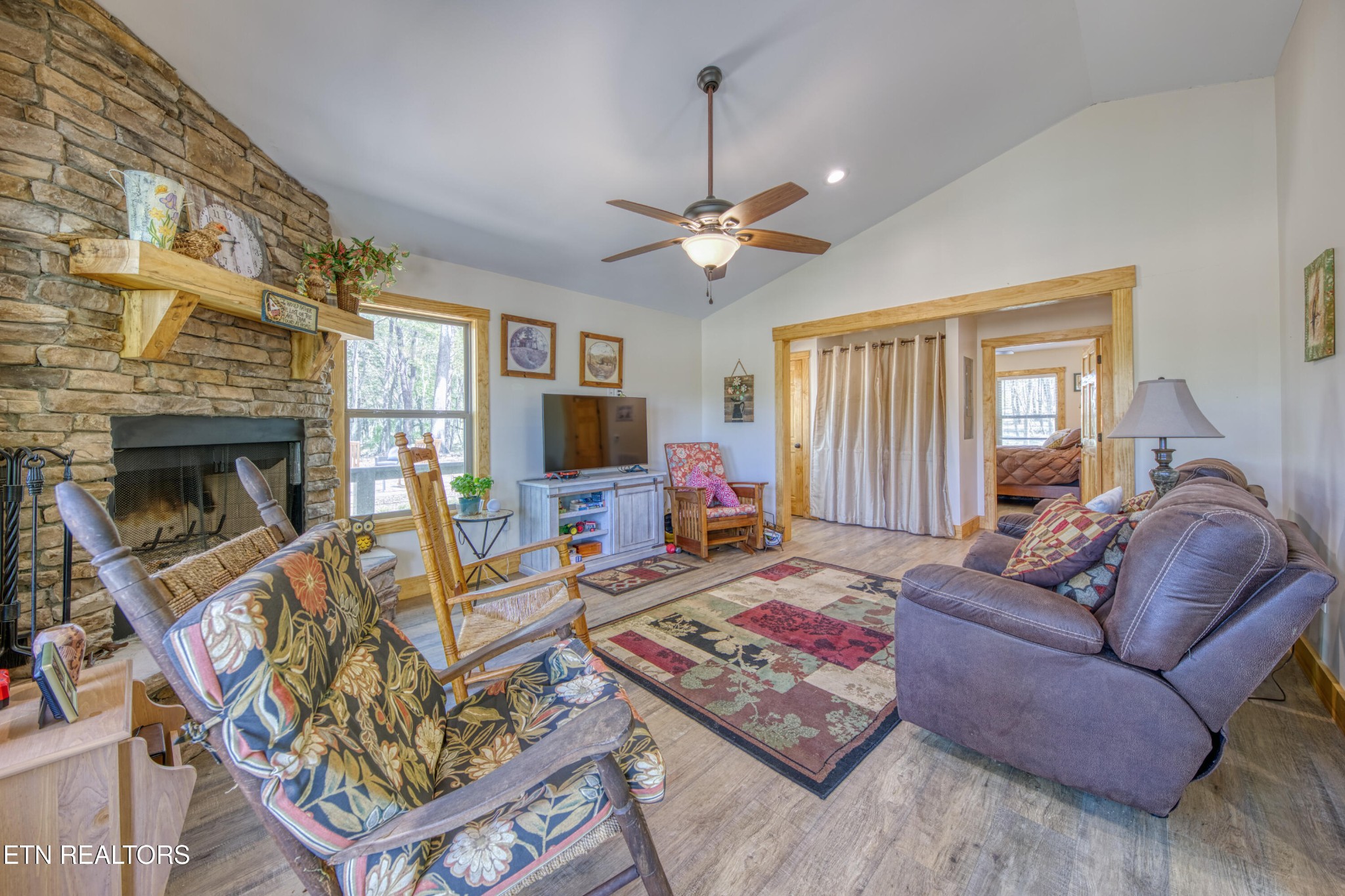 1040 Rdg Pt Trail Dandridge, TN 37725 - Photo 17 of 31 a living room with furniture a fireplace and a flat screen tv