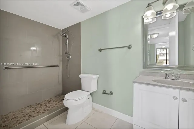 a bathroom with a granite countertop sink toilet a mirror and shower