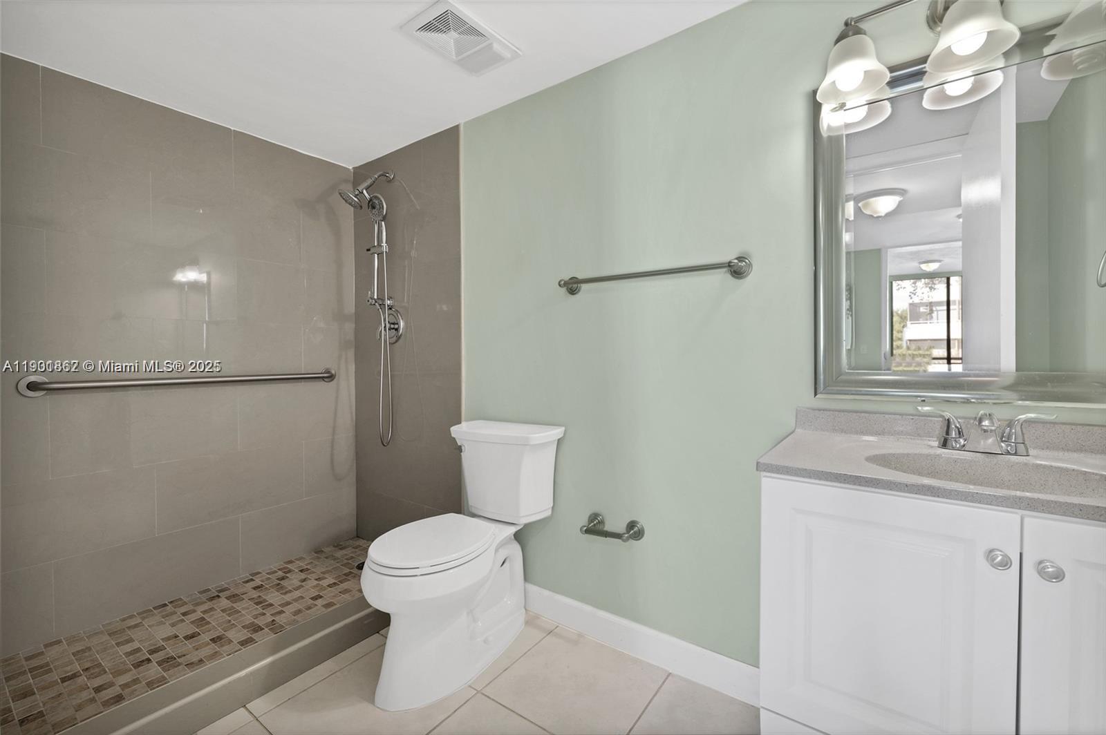 8335 Southwest 152nd Avenue, Unit B203 Miami, FL 33193 - Photo 8 of 10 a bathroom with a granite countertop sink toilet a mirror and shower