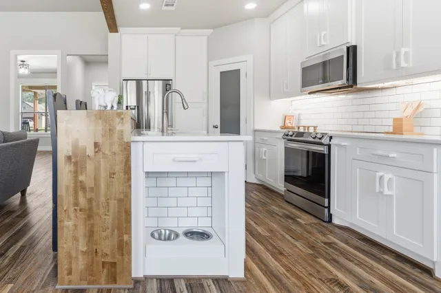 a kitchen with stainless steel appliances granite countertop a stove a microwave and a refrigerator