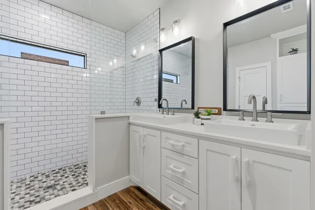 a bathroom with a sink a toilet a mirror and shower