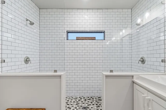 a bathroom with a sink a toilet a mirror and shower