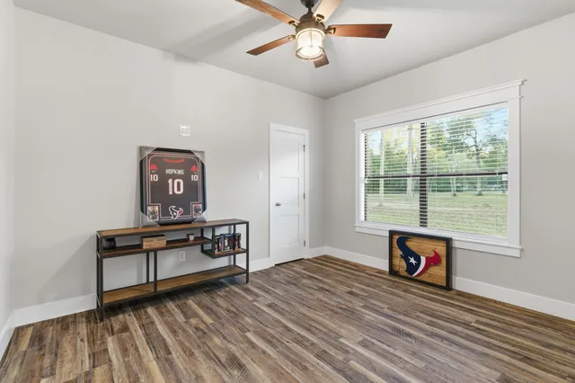 a view of a livingroom with wooden floor and a ceiling fan